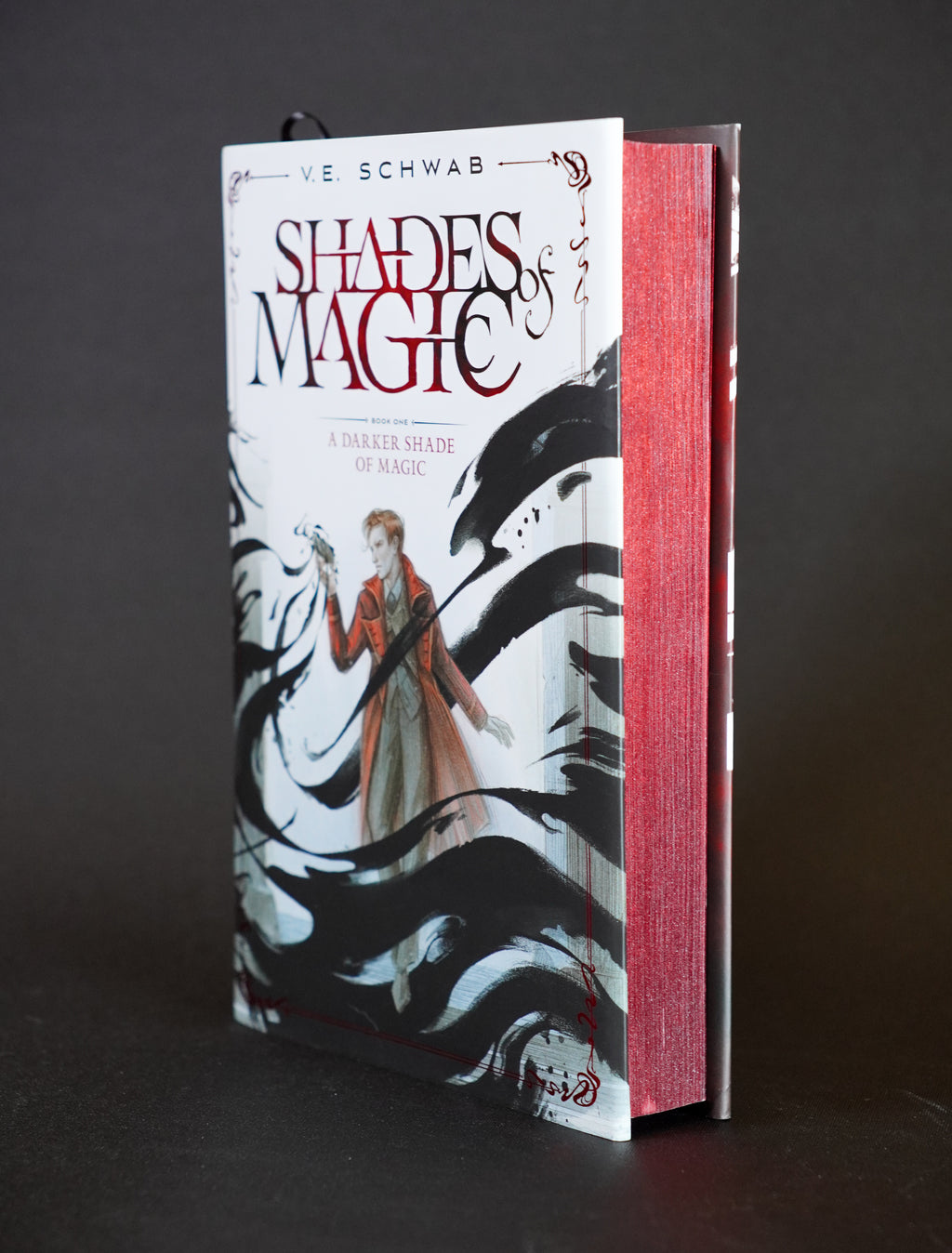 A Darker Shade of Magic Wraithmarked edition upright, showing the illustrated cover and metallic red page edges
