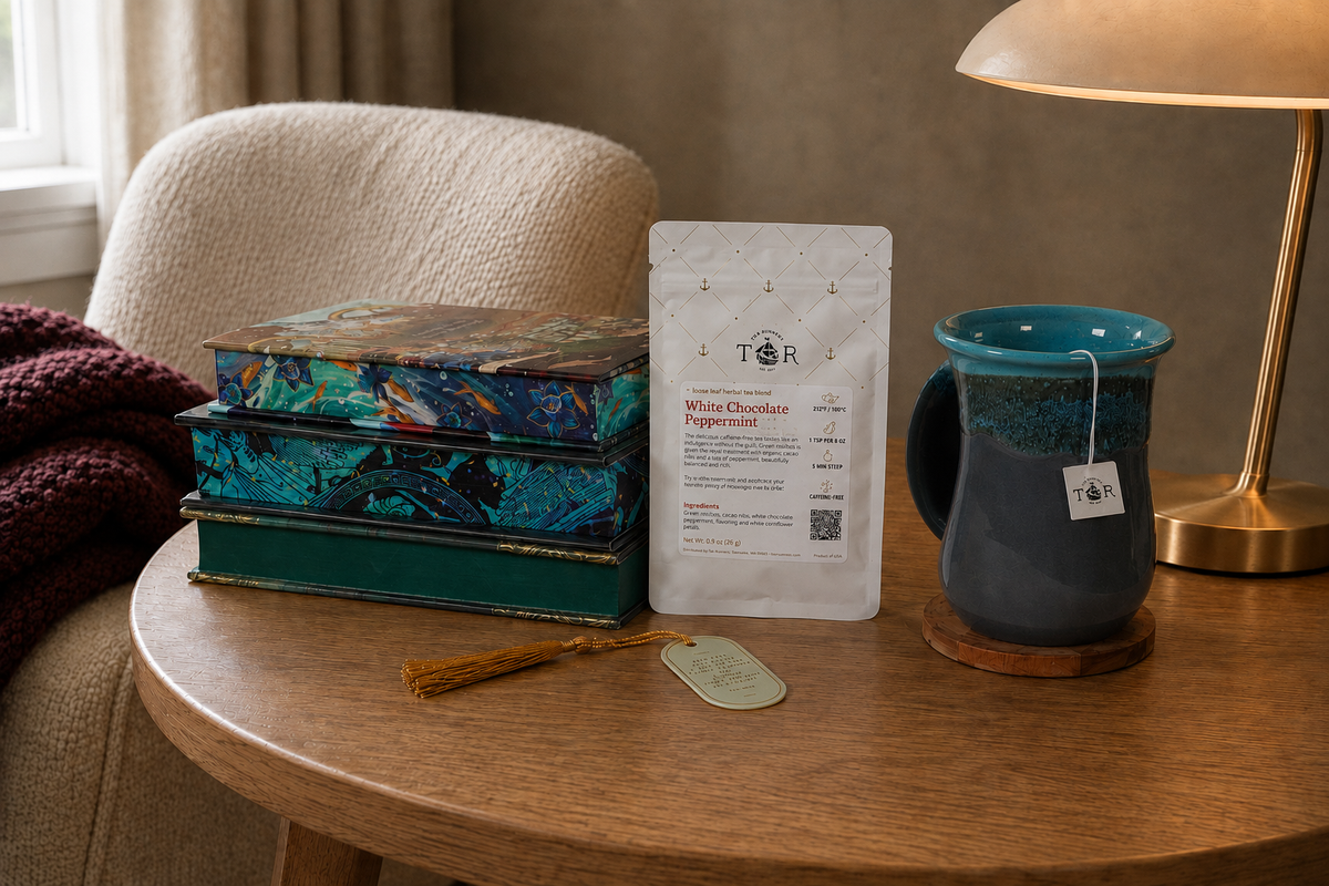 A cozy reading scene with special-edition books, a hand-warmer mug, Tea Runners tea, a bookmark, and a warm brass lamp.
