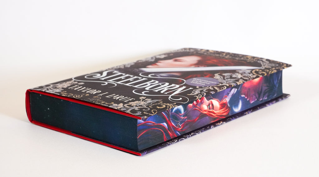 Steelborn lying flat, showing the illustrated fore-edge and dark sprayed page edges