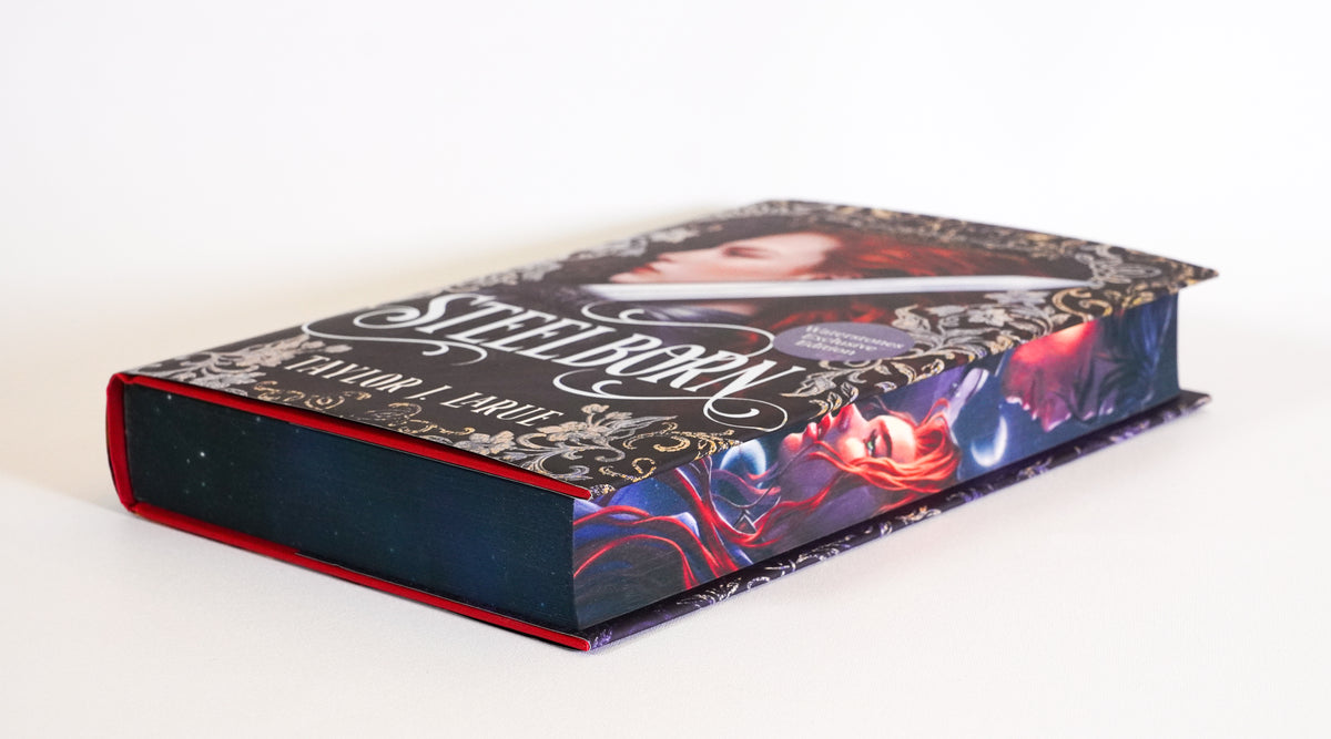 Steelborn lying flat, showing the illustrated fore-edge and dark sprayed page edges