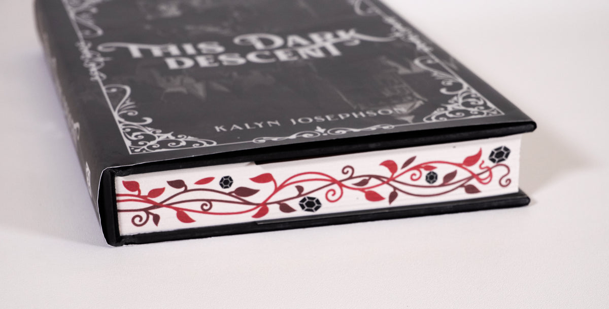 Decorated page-edge detail with red vines and black gems on This Dark Descent