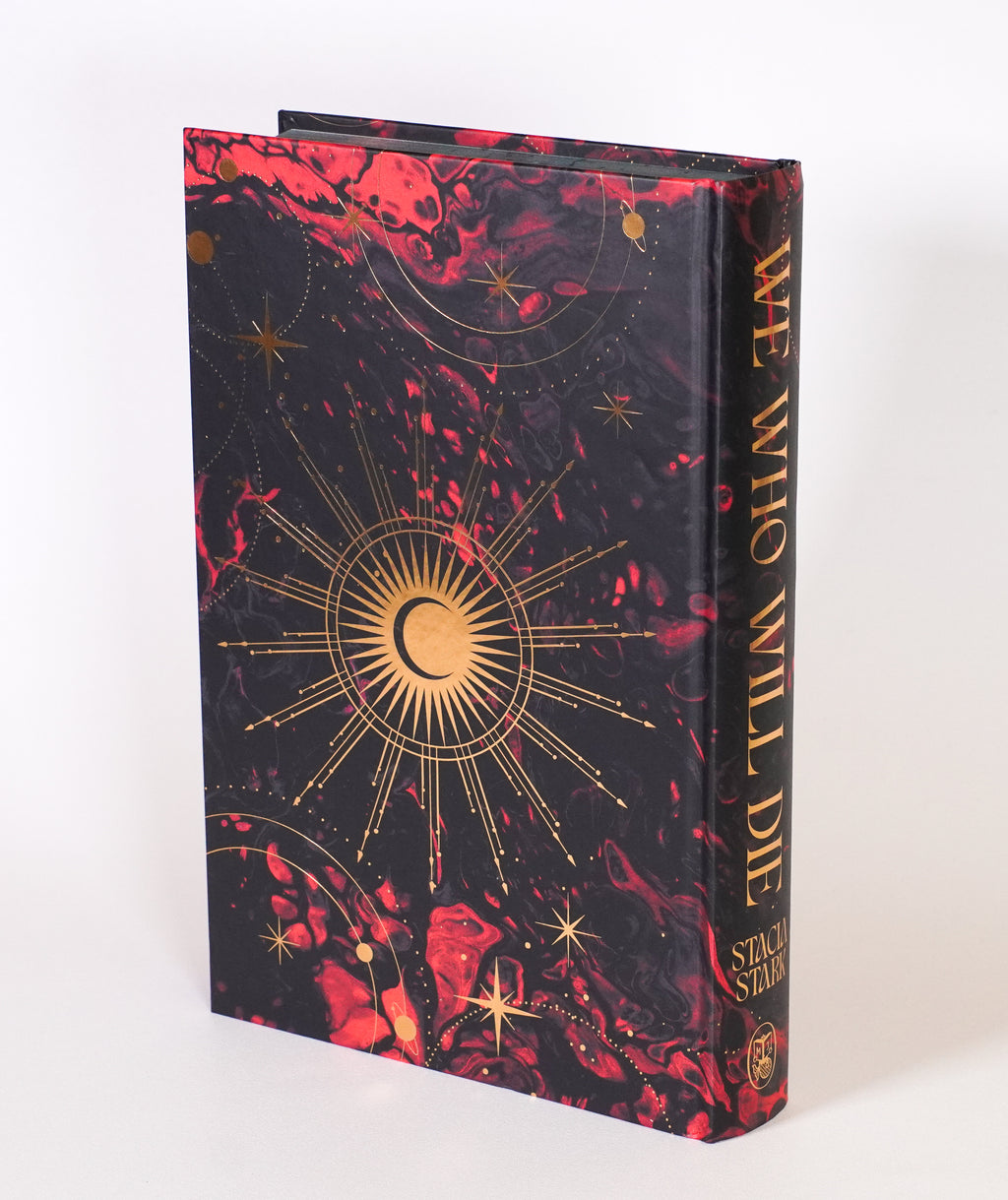 We Who Will Die FairyLoot edition without the dust jacket, showing the celestial gold foil design on the back hardcover and spine
