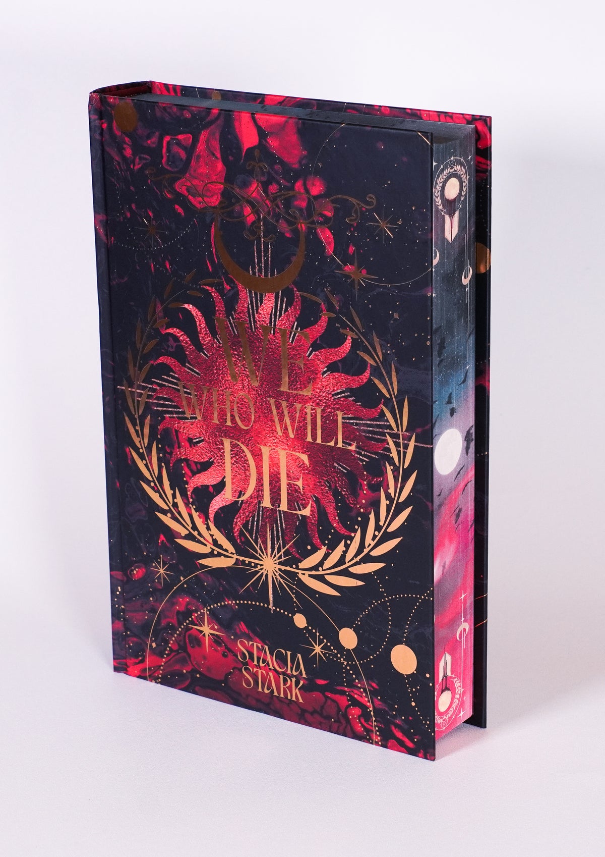 We Who Will Die FairyLoot edition without the dust jacket, showing the red-and-black front hardcover with gold foil and decorated fore-edge