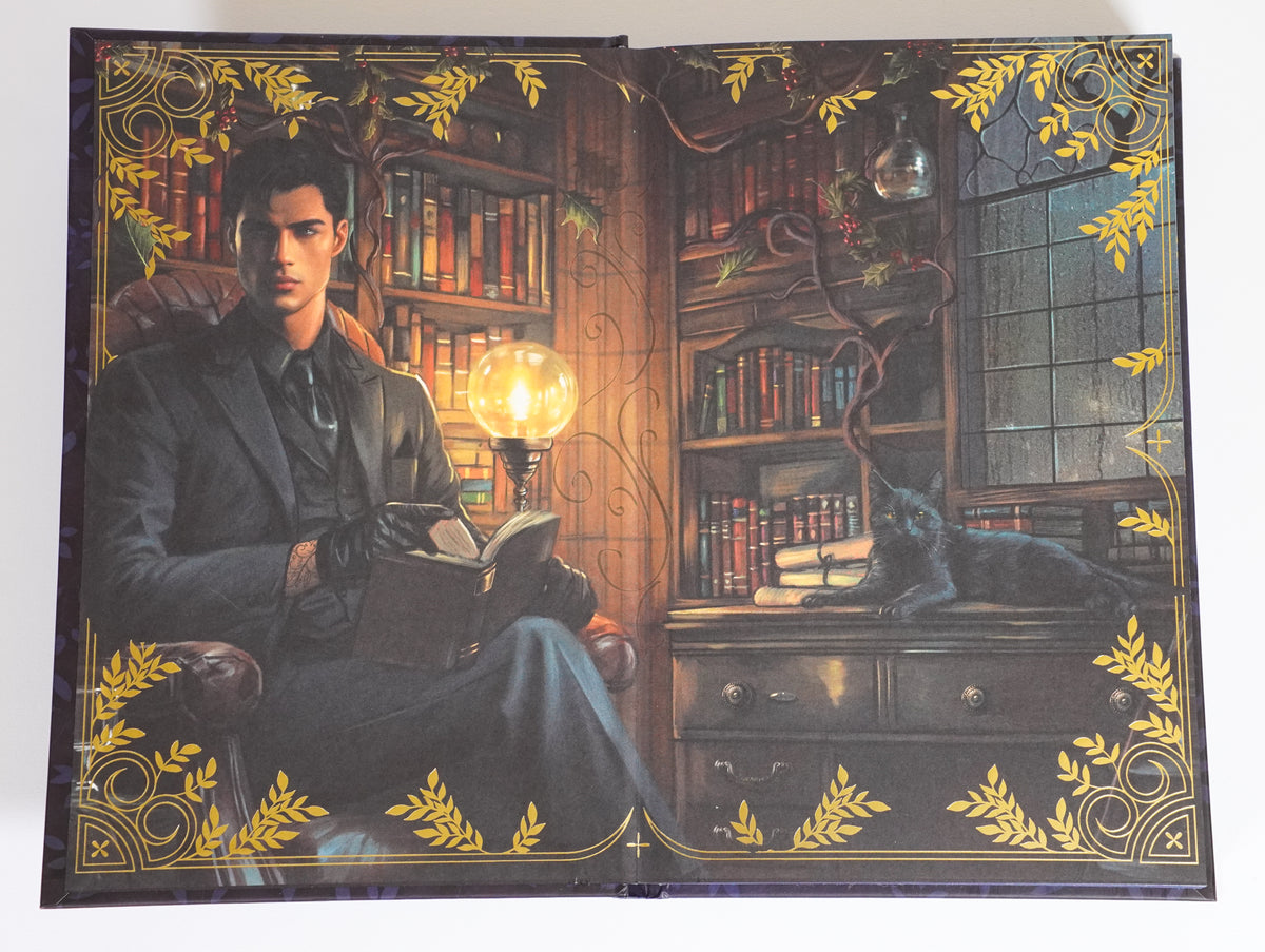 Illustrated endpaper spread in The Wren in the Holly Library FairyLoot edition, showing a man reading and a black cat in a library, framed by gold botanical decoration